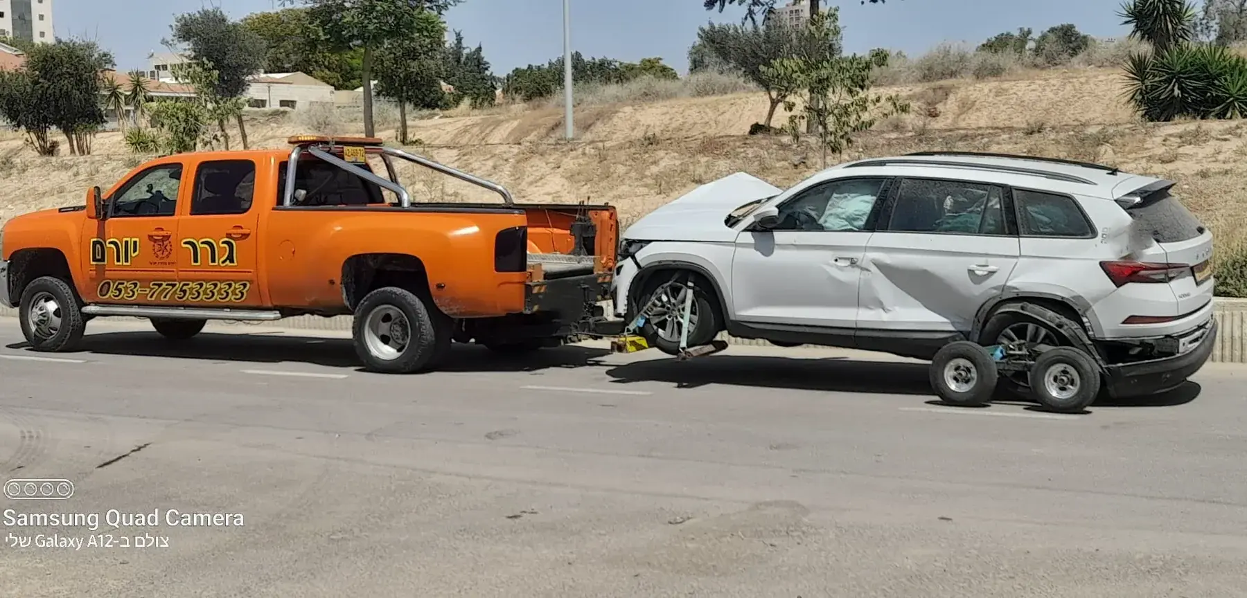 רכב שירות כתום של גרר יורם לצד רכב לבן