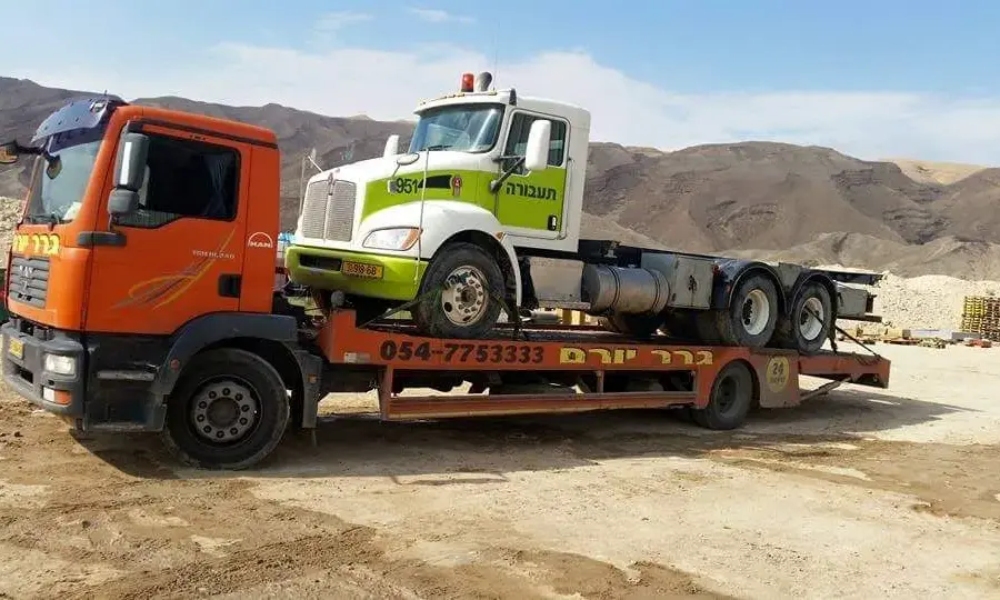 משאית גרר יורם מובילה משאית בשטח פתוח